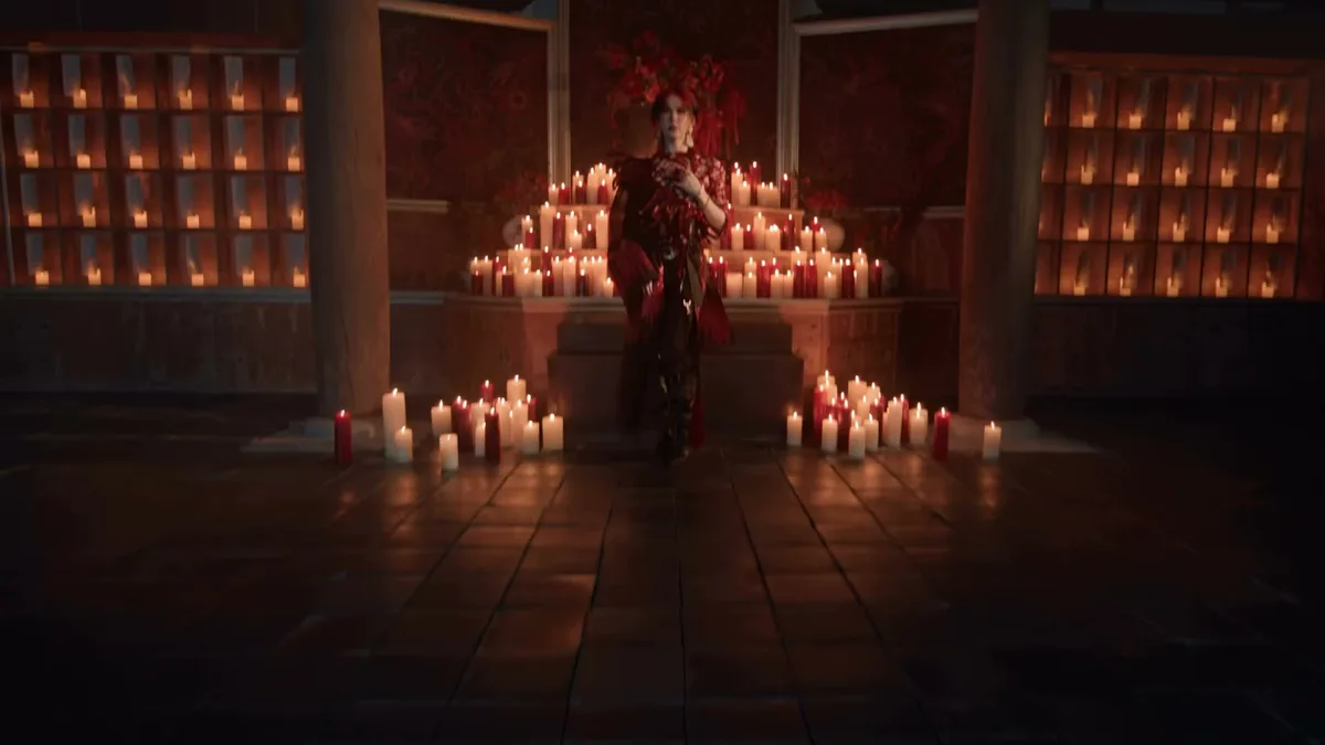Cena coreografada em uma sala com velas no videoclipe Hush, do XLOV