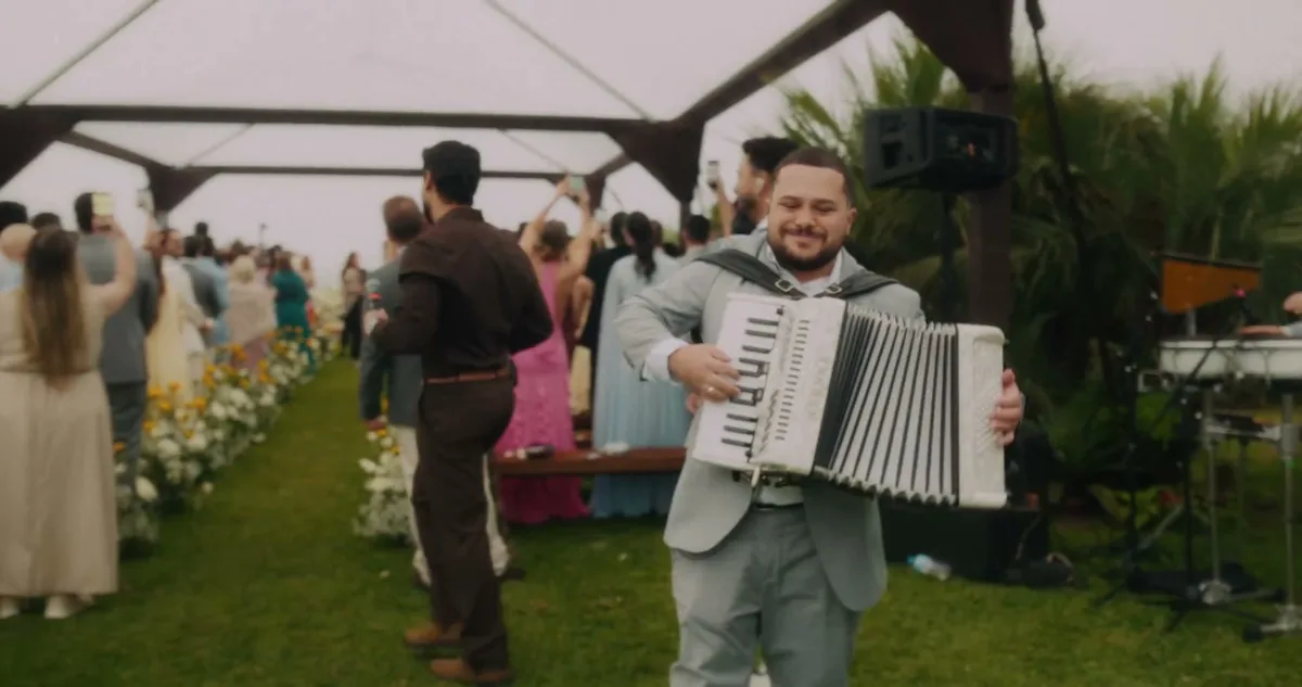Músico toca sanfona durante a celebração mostrada no clipe de Sem Pressa, Sem Pausa