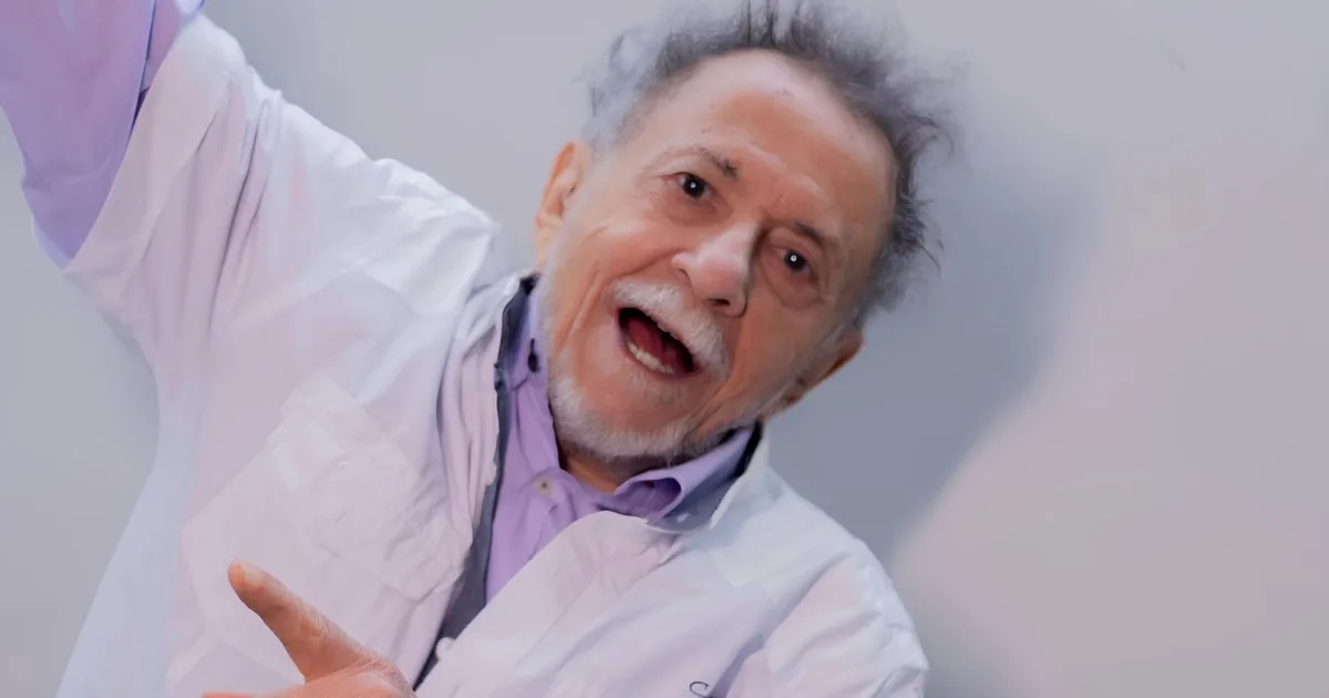 Tom Zé em retrato de divulgação, com camisa clara e braços levantados