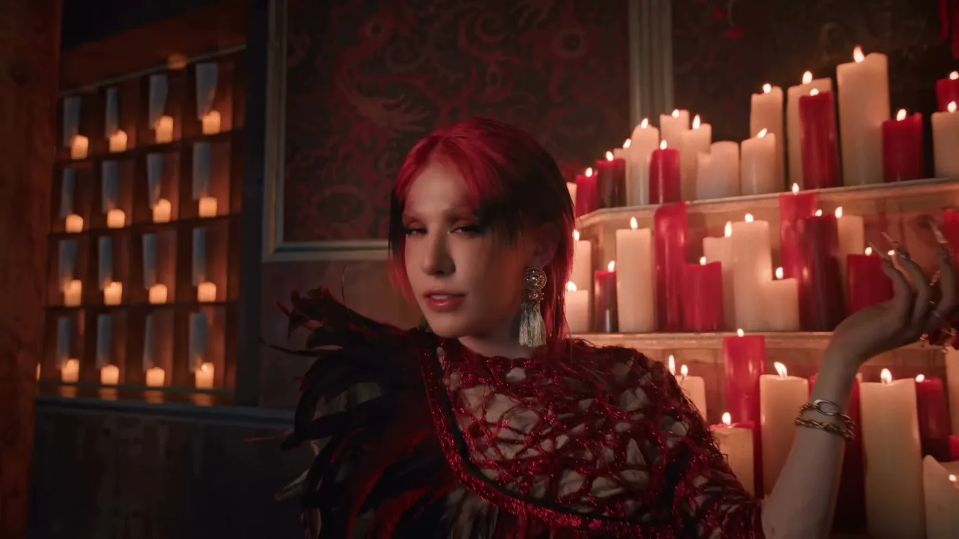 Integrante do XLOV em uma sala iluminada por velas no videoclipe Hush