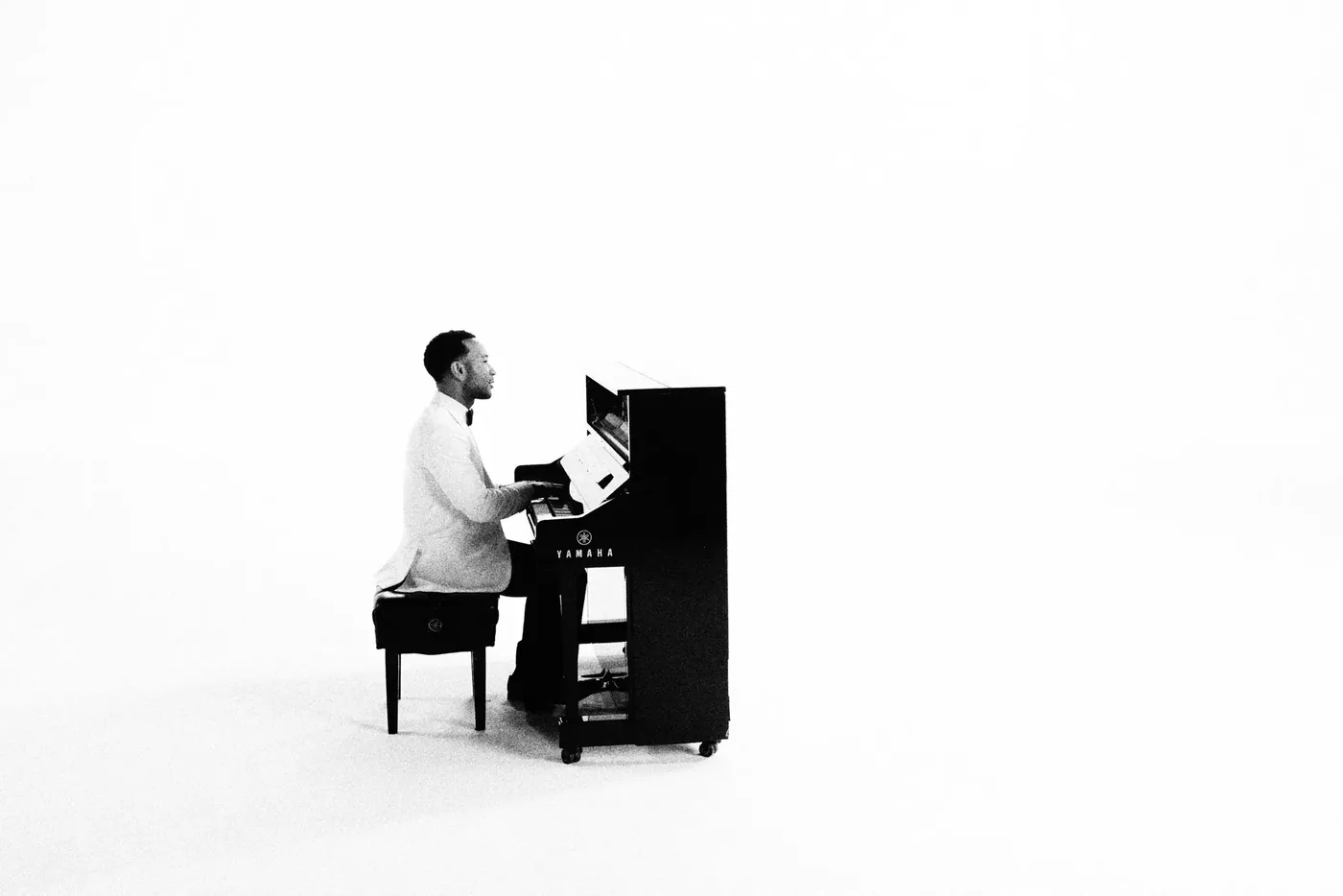 John Legend ao piano em fotografia de divulgação de Muse