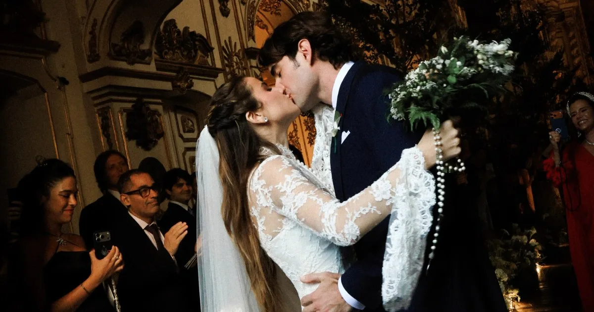Giulia Be e Conor Kennedy se beijam no interior da igreja durante o casamento.
